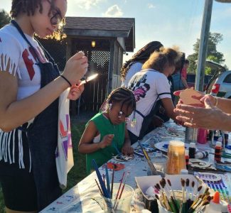 Youth painting horse cutouts at Derby Day.