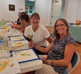 Adult students smile for the camera at Watercolor Wednesday.